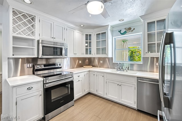 1674 Bunting Ln, Sanibel, FL 33957 - kitchen with stainless steel appliances, light countertops, white cabinets, ceiling fan, and recessed lighting