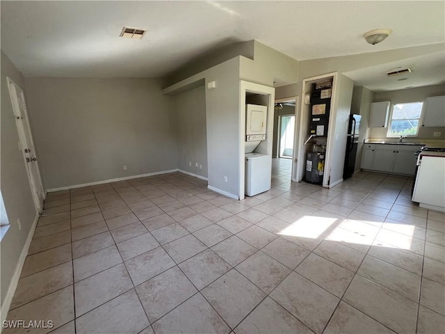 4869/4871 Leonard Blvd S, Lehigh Acres, FL 33973 - unfurnished living room featuring estacked washer and dryer and light tile patterned floors