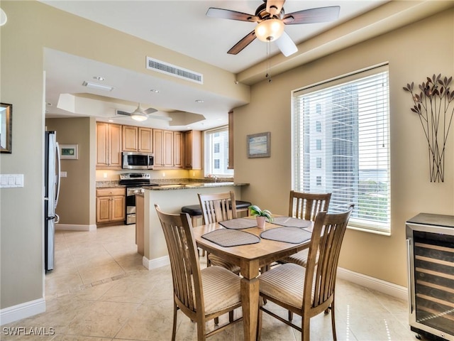 4182 Bay Beach Ln Unit 761, Fort Myers Beach, FL 33931 - dining room with wine cooler, a ceiling fan, a raised ceiling, and healthy amount of natural light