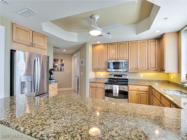 4182 Bay Beach Ln Unit 761, Fort Myers Beach, FL 33931 - kitchen with appliances with stainless steel finishes, a raised ceiling, light stone countertops, ceiling fan, and light brown cabinets