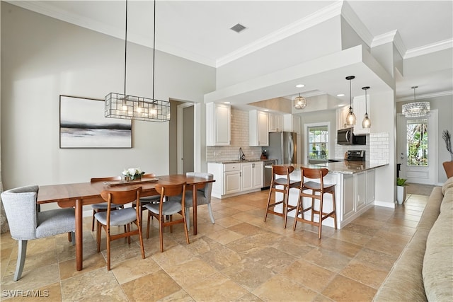 28283 Koi Way, Bonita Springs, FL 34135 - dining room with crown molding, stone tile floors, and a chandelier