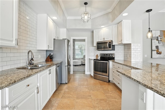 28283 Koi Way, Bonita Springs, FL 34135 - kitchen with appliances with stainless steel finishes, white cabinets, crown molding, light stone countertops, and backsplash