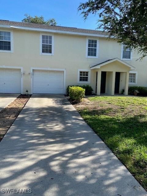 5265 Leeds Rd, Fort Myers, FL 33907 - view of front of home with stucco siding, a garage, and concrete driveway