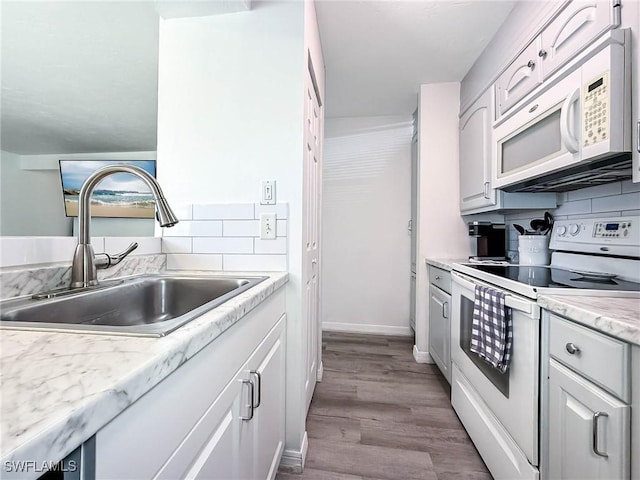13126 Feather Sound Dr Unit 310, Fort Myers, FL 34481 - kitchen featuring white appliances, light countertops, wood finished floors, and decorative backsplash