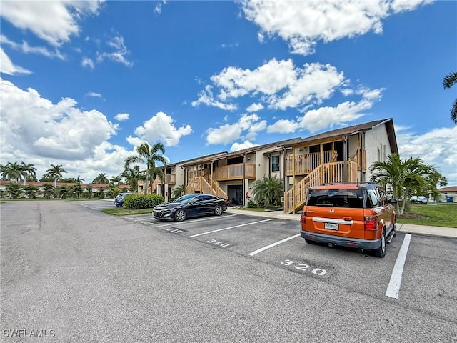 13126 Feather Sound Dr Unit 310, Fort Myers, FL 34481 - view of building exterior with stairs, uncovered parking, and a residential view