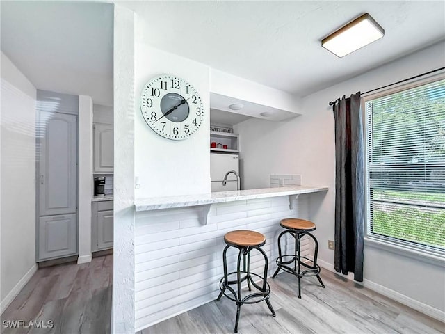 13126 Feather Sound Dr Unit 310, Fort Myers, FL 34481 - kitchen featuring fridge, a breakfast bar area, light wood-style floors, and healthy amount of natural light