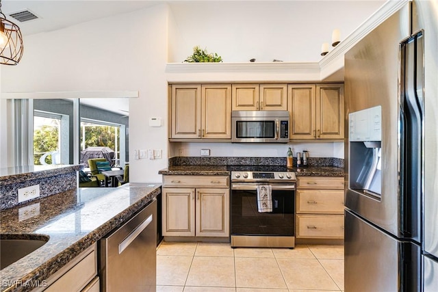 606 Mohawk Pkwy, Cape Coral, FL 33914 - kitchen with appliances with stainless steel finishes, light tile patterned flooring, light brown cabinetry, dark stone counters, and decorative light fixtures