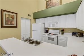 4105 Residence Dr Unit 722, Fort Myers, FL 33901 - kitchen featuring white appliances, white cabinets, light countertops, and a towering ceiling