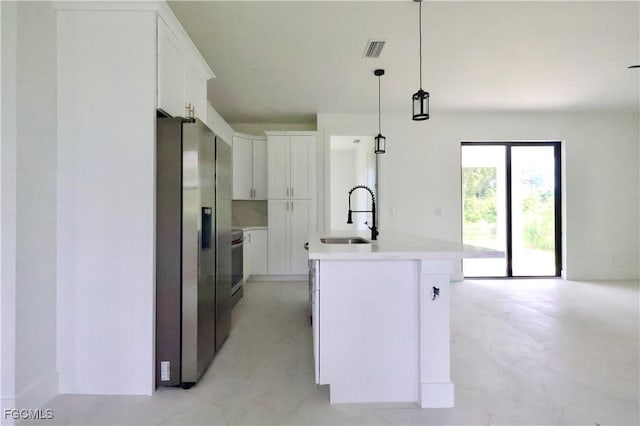 2713 8th St W, Lehigh Acres, FL 33971 - kitchen featuring stainless steel refrigerator with ice dispenser, white cabinetry, an island with sink, light countertops, and decorative light fixtures
