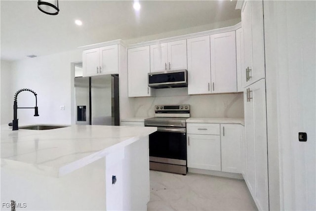 2713 8th St W, Lehigh Acres, FL 33971 - kitchen featuring appliances with stainless steel finishes, white cabinets, light stone countertops, recessed lighting, and light marble finish floors