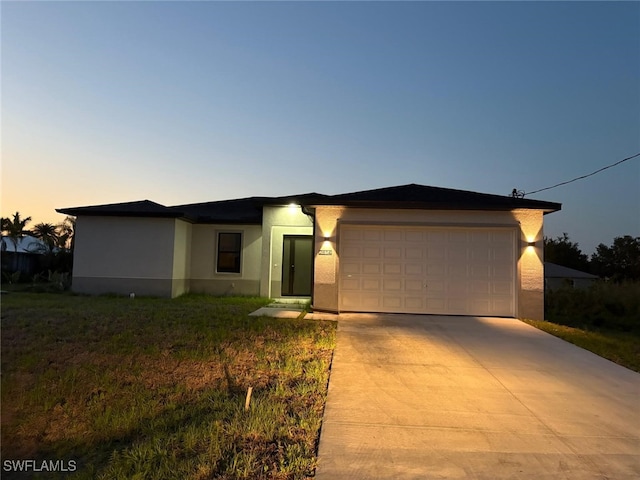 3113 58th St W, Lehigh Acres, FL 33971 - view of front facade with stucco siding, an attached garage, and concrete driveway