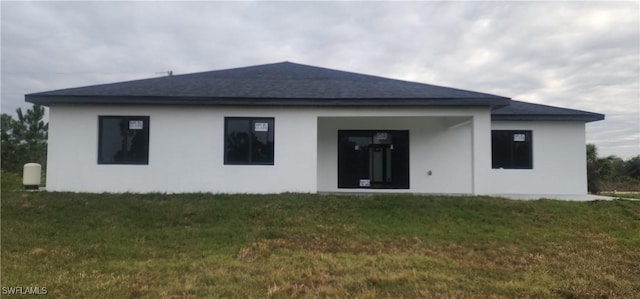 1215 Bayou St, Lehigh Acres, FL 33974 - back of property with a lawn and stucco siding