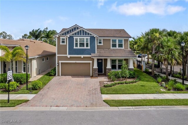 3240 Pilot Cir, Naples, FL 34120 - craftsman-style house featuring decorative driveway, an attached garage, and stone siding