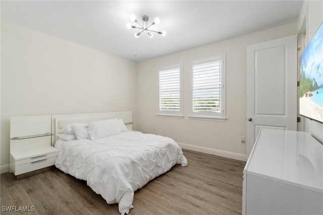 3240 Pilot Cir, Naples, FL 34120 - bedroom featuring wood finished floors and a chandelier