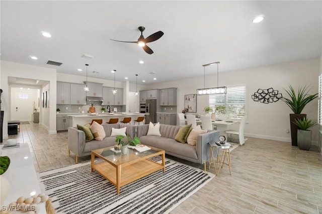 3240 Pilot Cir, Naples, FL 34120 - living area featuring ceiling fan, light wood-style flooring, recessed lighting, and a wood stove