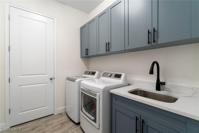 3240 Pilot Cir, Naples, FL 34120 - washroom featuring washing machine and clothes dryer, cabinet space, and light wood-style floors