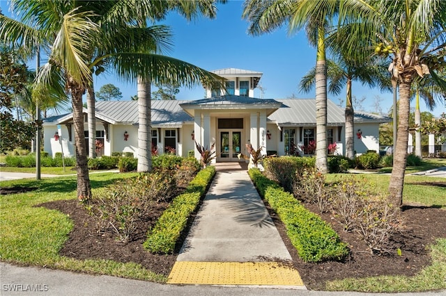 3240 Pilot Cir, Naples, FL 34120 - view of front of property featuring french doors, a metal roof, stucco siding, and a standing seam roof