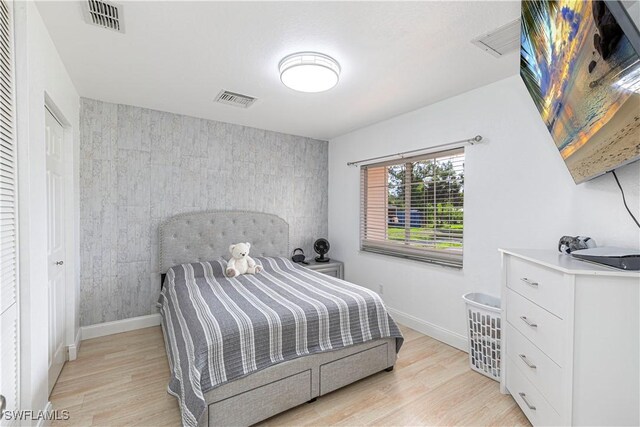 1271 16th St NE, Naples, FL 34120 - bedroom with light wood-style flooring and an accent wall