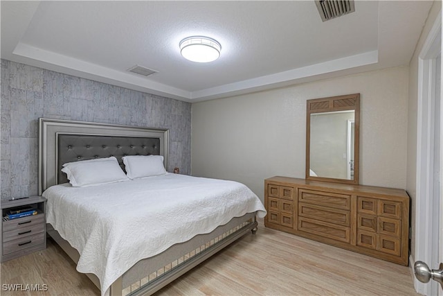 1271 16th St NE, Naples, FL 34120 - bedroom featuring a tray ceiling and wood finished floors