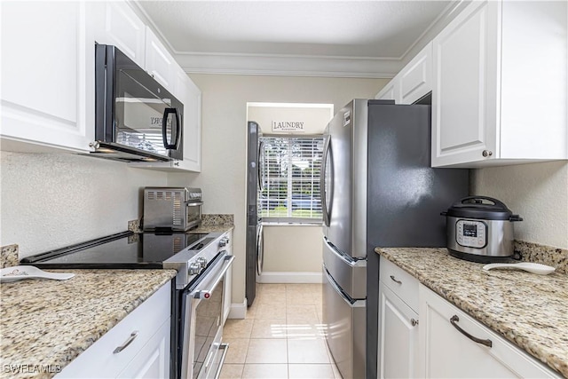 1271 16th St NE, Naples, FL 34120 - kitchen with stainless steel electric range oven, black microwave, white cabinets, light stone counters, and crown molding