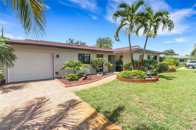 1015 El Valle Ave, Fort Myers, FL 33919 - ranch-style house with a garage, stucco siding, decorative driveway, and a front lawn