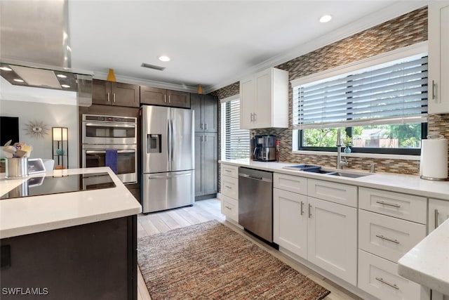 1015 El Valle Ave, Fort Myers, FL 33919 - kitchen with stainless steel appliances, island exhaust hood, decorative backsplash, white cabinets, and recessed lighting