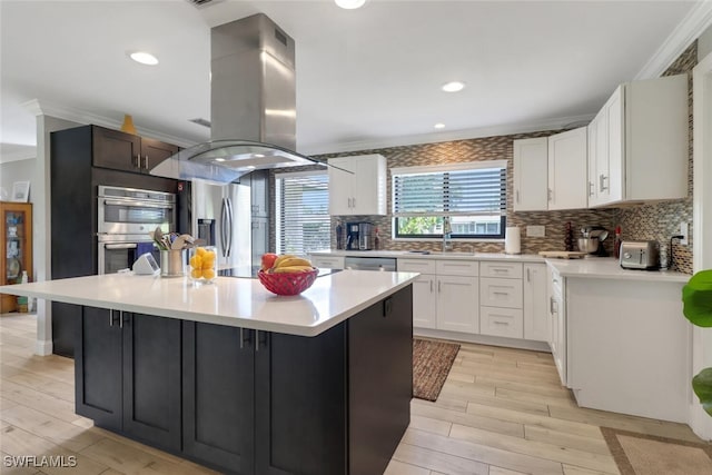 1015 El Valle Ave, Fort Myers, FL 33919 - kitchen with island exhaust hood, stainless steel appliances, ornamental molding, light countertops, and a center island
