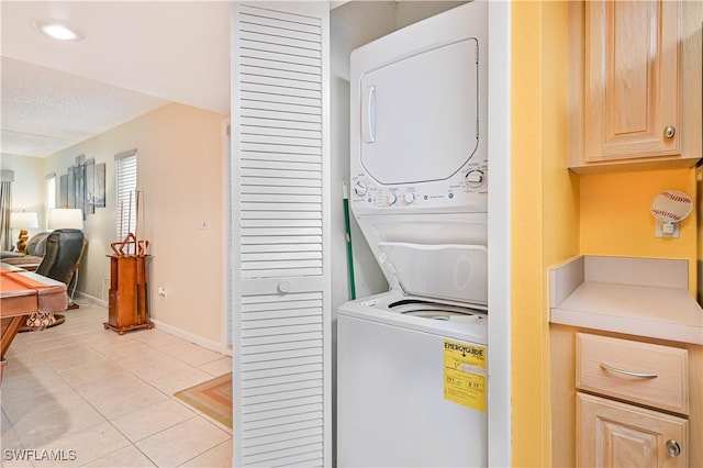 4217 SE 19th Ave Unit 110, Cape Coral, FL 33904 - laundry area featuring stacked washer and clothes dryer, light tile patterned floors, and a textured ceiling