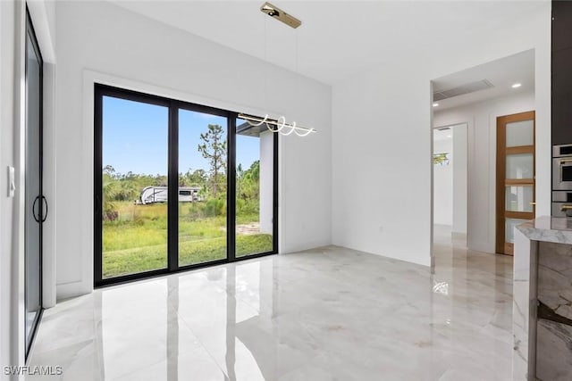 3614 22nd Ave NE, Naples, FL 34120 - spare room featuring light marble finish flooring and a chandelier