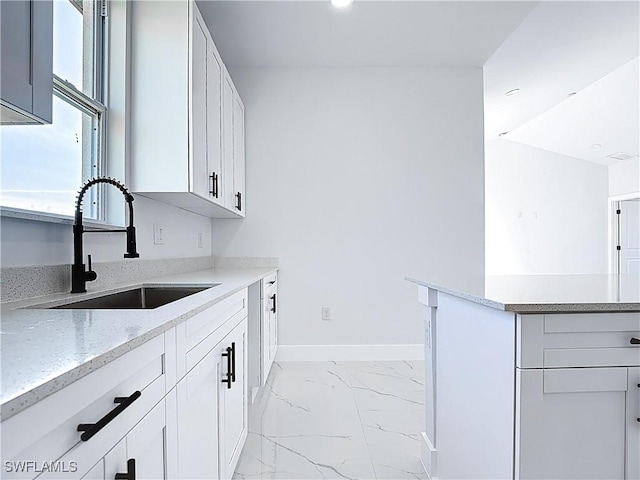 5001 Bywood St, Lehigh Acres, FL 33971 - kitchen with light marble finish flooring, light stone counters, and white cabinetry