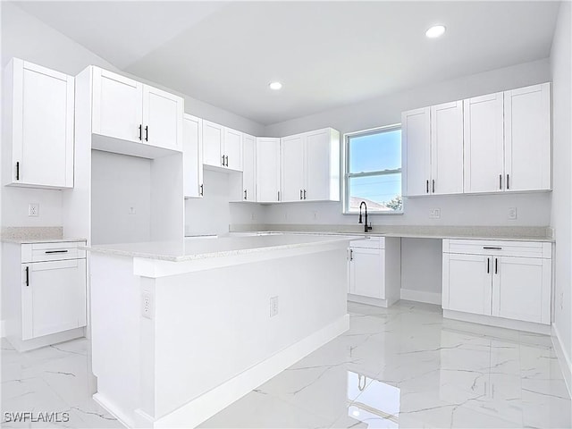 5001 Bywood St, Lehigh Acres, FL 33971 - kitchen with light marble finish floors, a center island, recessed lighting, white cabinets, and light countertops