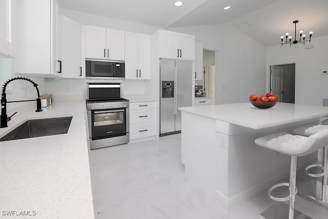 5001 Bywood St, Lehigh Acres, FL 33971 - kitchen with appliances with stainless steel finishes, vaulted ceiling, white cabinetry, a breakfast bar area, and light countertops