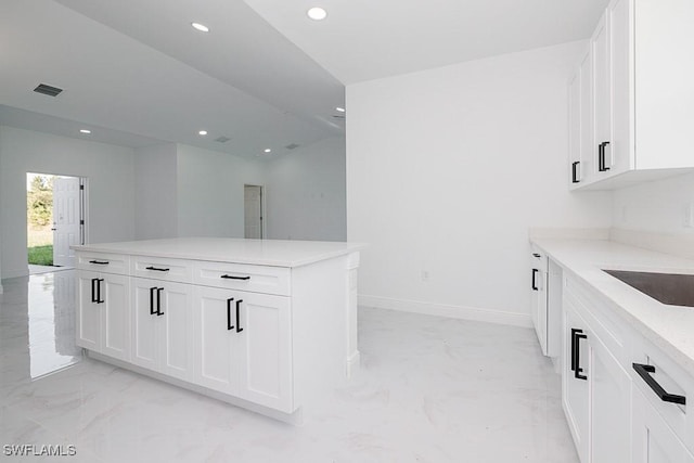 5001 Bywood St, Lehigh Acres, FL 33971 - kitchen with light marble finish flooring, recessed lighting, white cabinetry, light countertops, and a kitchen island