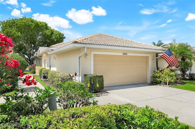 6956 Lone Oak Blvd, Naples, FL 34109 - view of property exterior with a tiled roof, stucco siding, driveway, and an attached garage