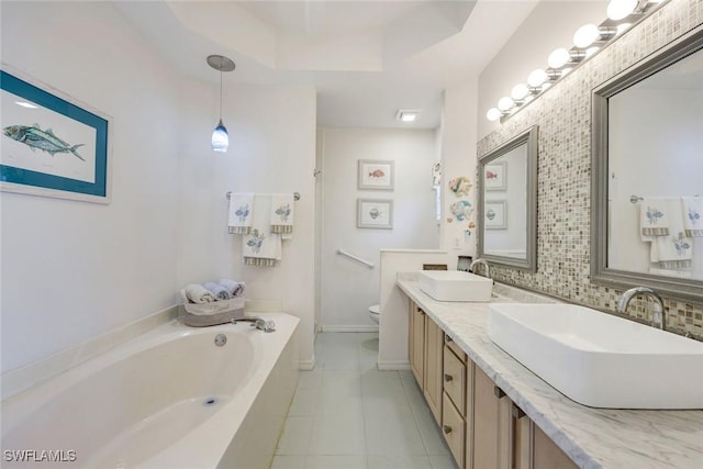 6956 Lone Oak Blvd, Naples, FL 34109 - full bathroom with a bath, double vanity, tile patterned flooring, a tray ceiling, and decorative backsplash