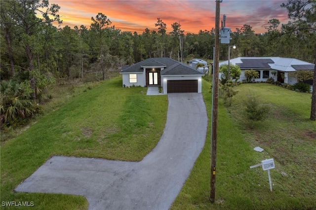 3525 43rd Ave NE, Naples, FL 34120 - ranch-style house featuring an attached garage, a front lawn, asphalt driveway, french doors, and a view of trees