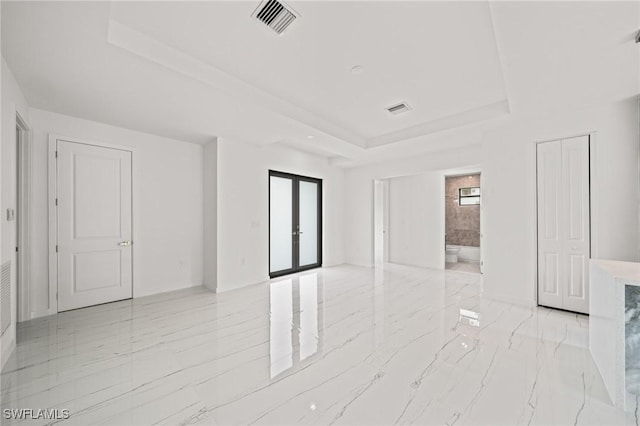 3525 43rd Ave NE, Naples, FL 34120 - empty room with a raised ceiling, light marble finish flooring, and french doors
