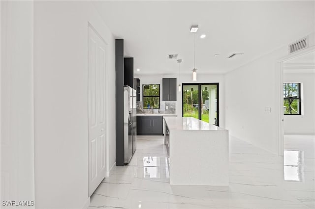 3525 43rd Ave NE, Naples, FL 34120 - kitchen with stainless steel fridge with ice dispenser, light marble finish floors, a center island, light countertops, and pendant lighting
