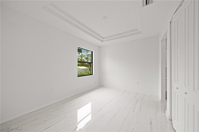 3525 43rd Ave NE, Naples, FL 34120 - spare room featuring a tray ceiling and marble look tiles