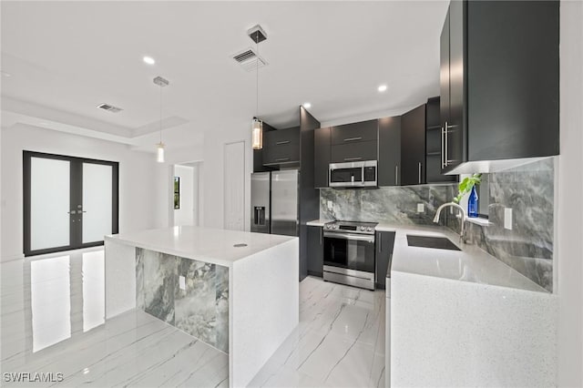 3525 43rd Ave NE, Naples, FL 34120 - kitchen featuring stainless steel appliances, dark cabinetry, modern cabinets, backsplash, and a kitchen island