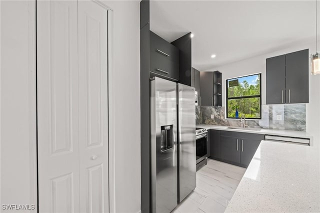 3525 43rd Ave NE, Naples, FL 34120 - kitchen with appliances with stainless steel finishes, modern cabinets, tasteful backsplash, decorative light fixtures, and gray cabinets