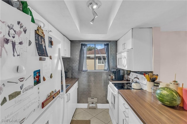 3284 Royal Canadian Trce Unit 4, Fort Myers, FL 33907 - kitchen with white appliances, wooden counters, light tile patterned floors, a tray ceiling, and white cabinetry