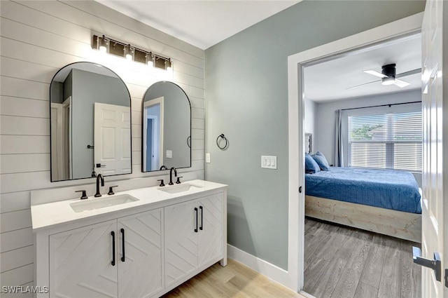 692 Hadley St E, Naples, FL 34104 - bathroom with connected bathroom, wood finished floors, double vanity, a ceiling fan, and wooden walls