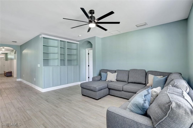 692 Hadley St E, Naples, FL 34104 - living area with arched walkways, ceiling fan, and light wood-type flooring
