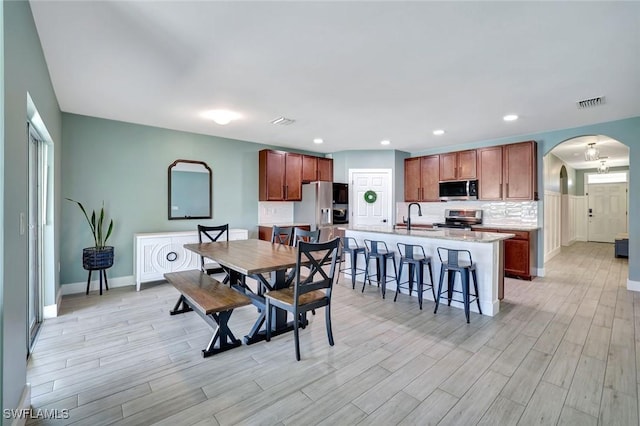 692 Hadley St E, Naples, FL 34104 - dining area with arched walkways, light wood-style flooring, and recessed lighting