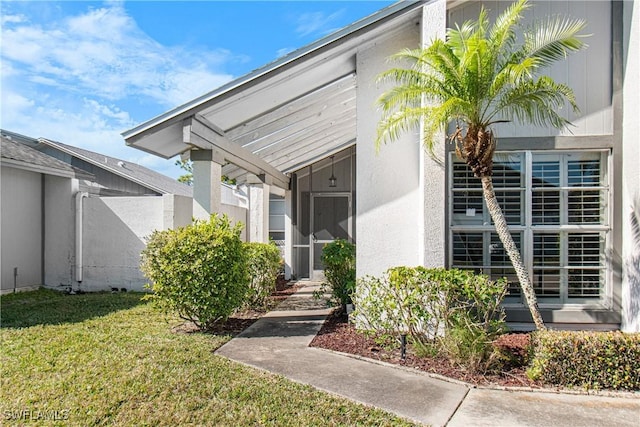 9761 Maplecrest Cir, Lehigh Acres, FL 33936 - doorway to property with a lawn and stucco siding