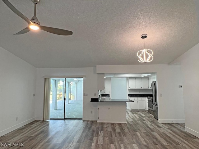 625 SE 35th Ter, Cape Coral, FL 33904 - kitchen with dark countertops, stainless steel appliances, a textured ceiling, open floor plan, and wood finished floors