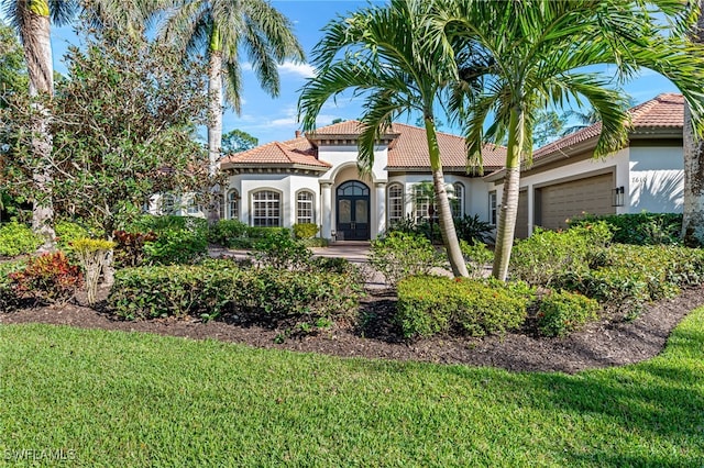 7610 Palmer Ct, Naples, FL 34113 - mediterranean / spanish house featuring stucco siding, an attached garage, a tiled roof, and a front yard