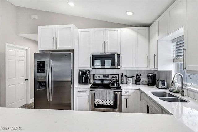 851 102nd Ave N, Naples, FL 34108 - kitchen featuring appliances with stainless steel finishes, vaulted ceiling, white cabinets, decorative backsplash, and recessed lighting