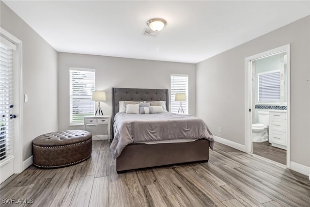 851 102nd Ave N, Naples, FL 34108 - bedroom with wood finished floors, ensuite bath, and multiple windows